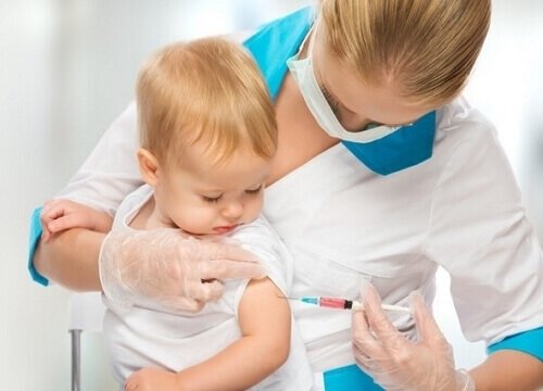 Lekarz szczepi niemowlę