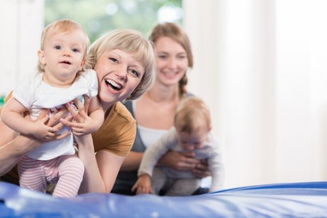 Uśmiechnięta mama prowadząca dziecko po macie