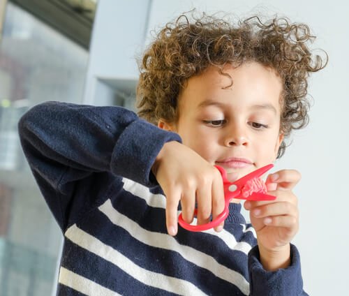 Zajęcia manualne dla dzieci - chłopiec wycina