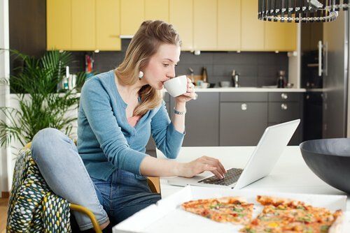 Zła dieta karmiącej piersią - kobieta pije kawę i je pizzę