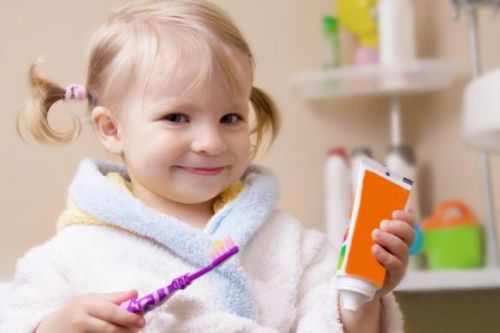 Dziewczynka myje zęby - sposób na zapobieganie pojawieniu się języka geograficznego