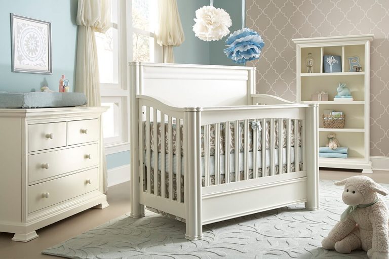 Łóżeczko dla dziecka stojące na środku biało-niebieskiego pokoju