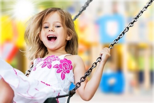 Roześmiana dziewczynka na huśtawce