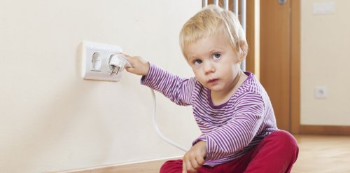 Dziecko bawi się gniazdkiem elektrycznym