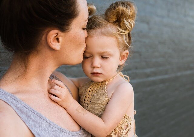 Mama całująca córkę trzymaną na rękach - nietypowe imiona dla córki