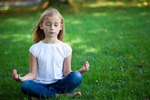 Dziewczynka medytuje na trawie