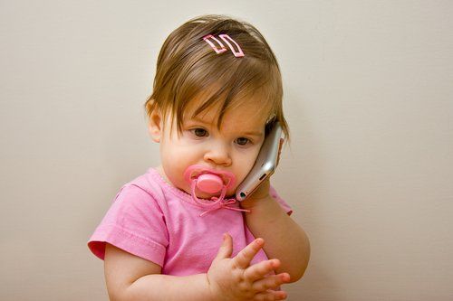 Dziewczynka rozmawia przez zabawkowy telefon