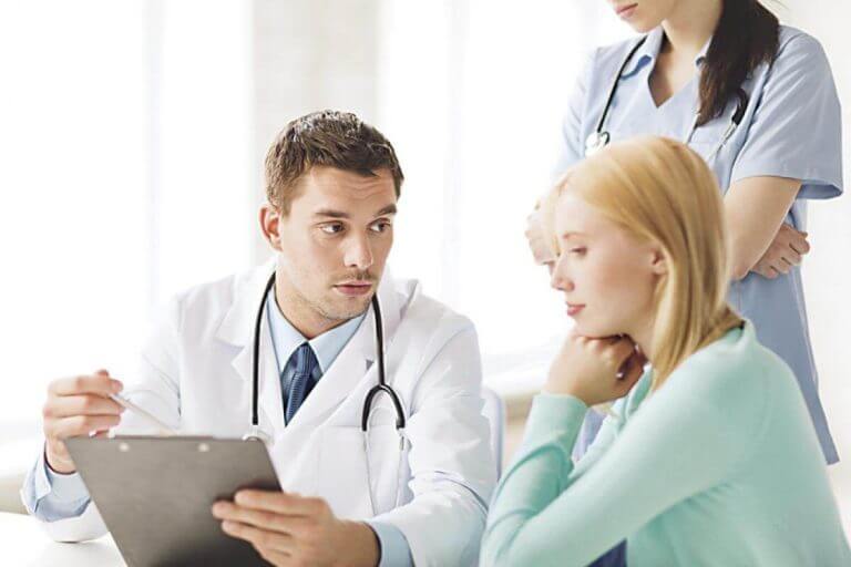 Lekarz i pielęgniarka pokazujący pacjentce wyniki badań