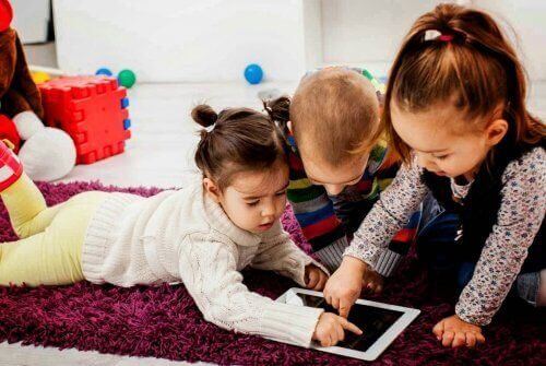 Pokolenie alfa - dzieci na dywanie bawią się tabletem