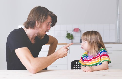Tata grożący palcem córce przy stole - wyznaczanie granic dziecku
