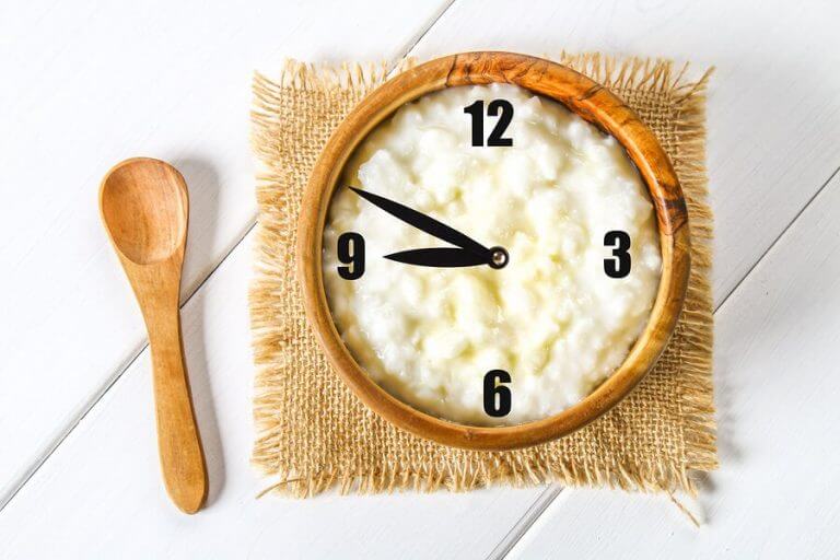 Zegar na misce z ryżem i leżąca obok łyżka