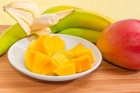 Banan i jabłko pokrojone na talerzu