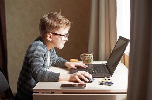 Chłopiec wpatrzony w komputer