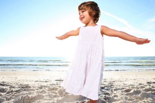 Dziewczynka w białej sukience nad morzem