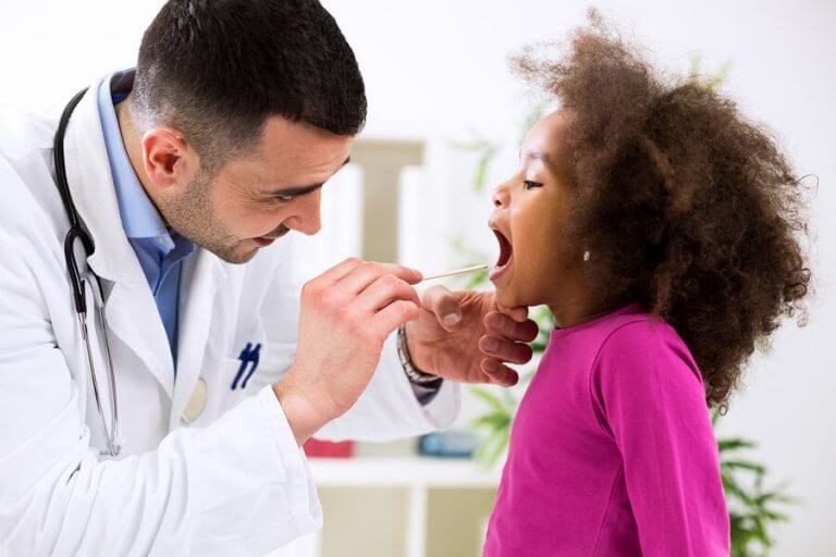 Lekarz zaglądający dziewczynce do gardła