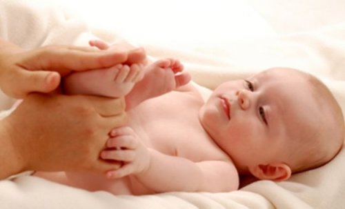 Mama masująca stopy niemowlęcia - refleksologia