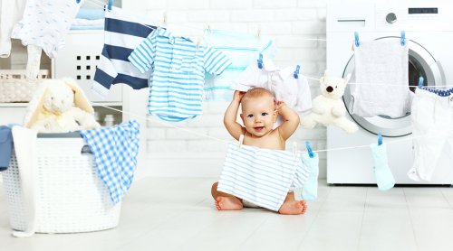 Niemowlak bawiący się ubraniami w pralni