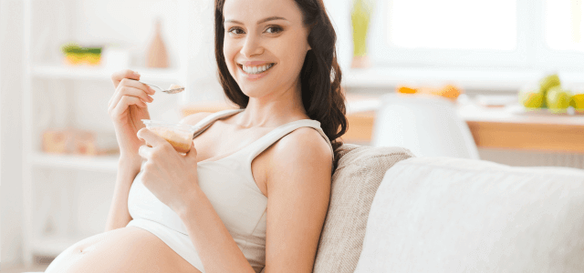 Kobieta w ciąży jedząca jogurt - naturalne probiotyki