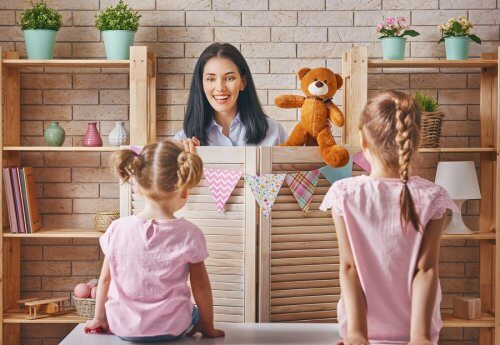 Mama robiąca przedstawienie z zabawkami dla dwóch córek