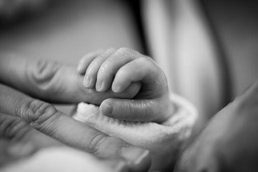 Rączka niemowlęcia trzymająca palec dorosłego
