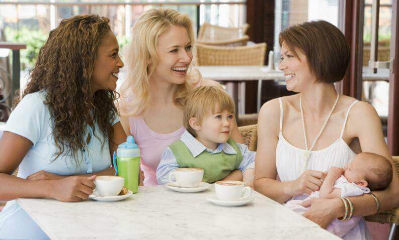 Trzy kobiety z dziećmi przy stole - zalety ciąży