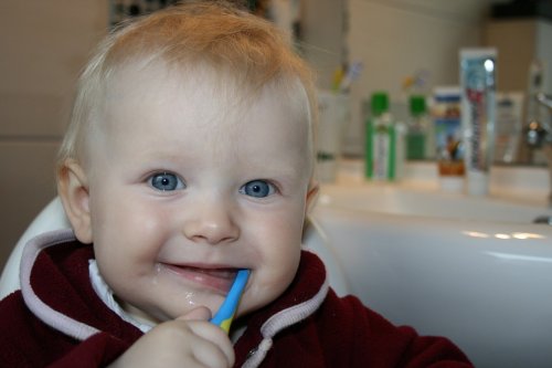 Uśmiechnięte dziecko myjące zęby szczoteczką