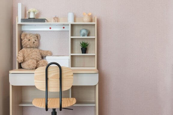 Biurko i krzesło dziecka na tle różowej ściany