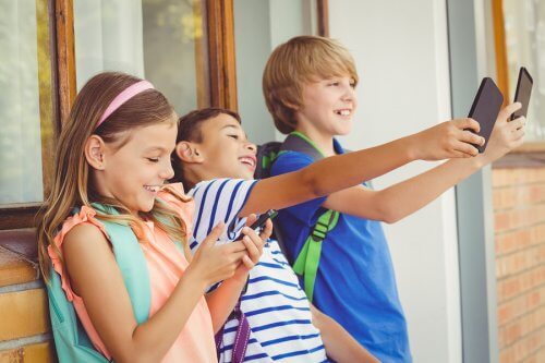 Dziewczynka i dwóch chłopców robiących selfie