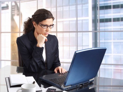Kobieta w okularach pracująca na laptopie
