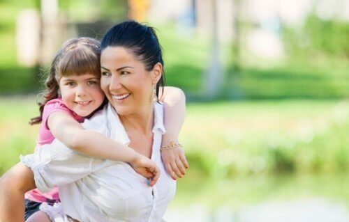 Mama nosząca córkę na plecach