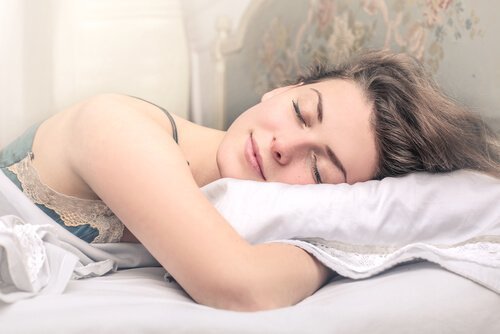 Uśmiechnięta kobieta śpiąca w łóżku