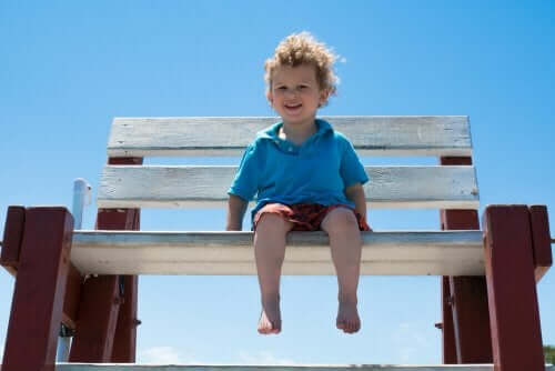 Bosy chłopiec na ławce na plaży - jak dbać o stopy dziecka