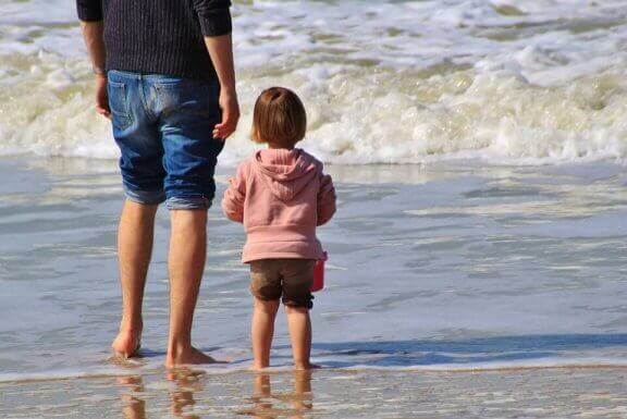 Tata i dziecko stojący na brzegu morza