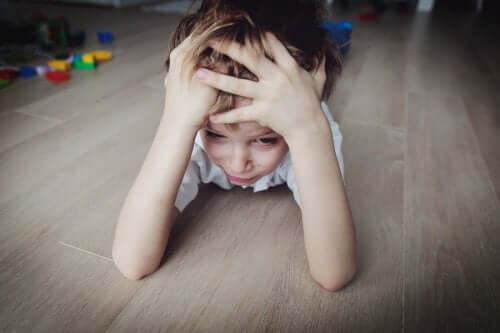 Zestresowany chłopiec leżący na podłodze - jak ochronić dziecko przed stresem