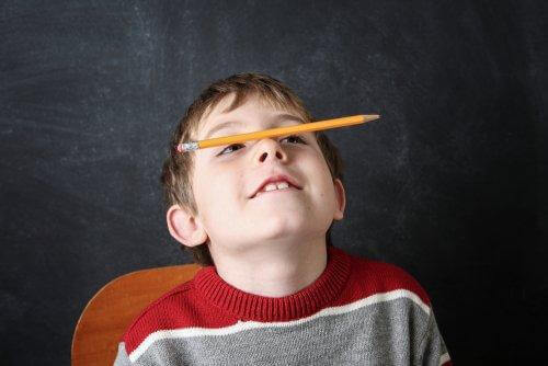 Chłopiec trzymający ołówek na nosie - stereotypie w dzieciństwie