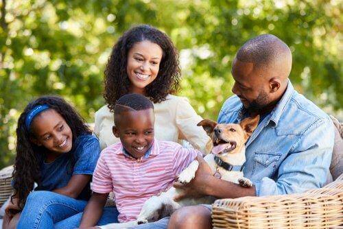 Uśmiechnięci rodzice, dzieci i pies - socjalizacja dziecka