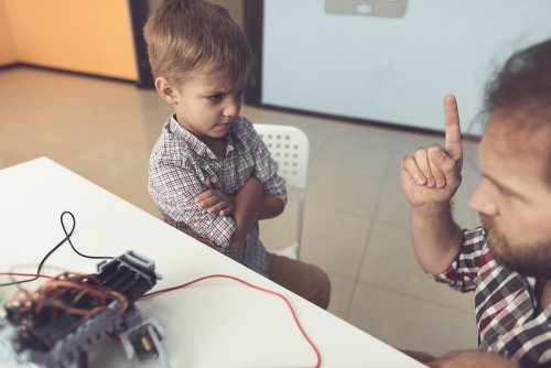 Tata grożący synowi palcem