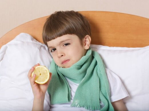 Chłopiec w łóżku z szalikiem na gardle