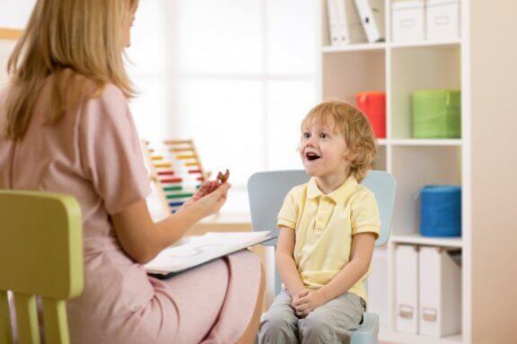 Psycholog rozmawiająca z uśmiechniętym chłopcem