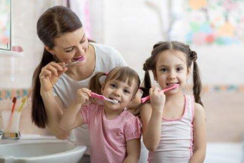 Mama i dwie córki myją zęby