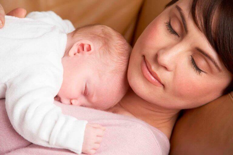 Kobieta przytulająca niemowlę - okres połogu