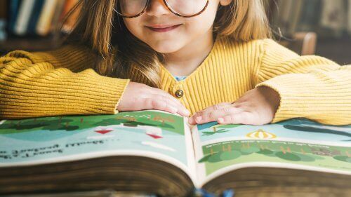 Dziewczynka czytająca książkę, której autorem jest Roald Dahl