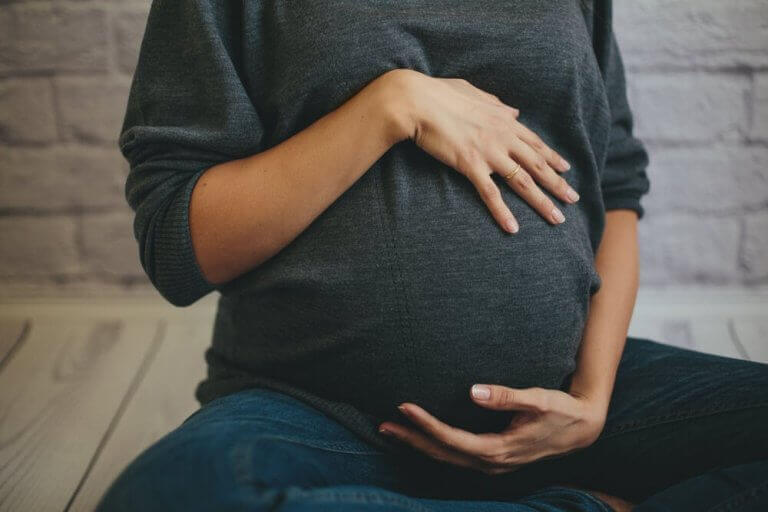 Kobieta w ciąży trzymająca się za brzuch - uraz mnogi w ciąży