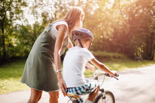 Mama ucząca syna jazdy na rowerze