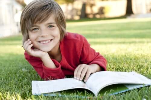 Chłopiec czytający na trawie