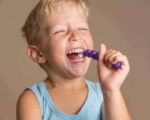 Dziecko myjące zęby pastą zawierającą fluor